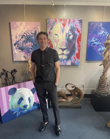 david in front of his artwork. panda, lion, cheetah.